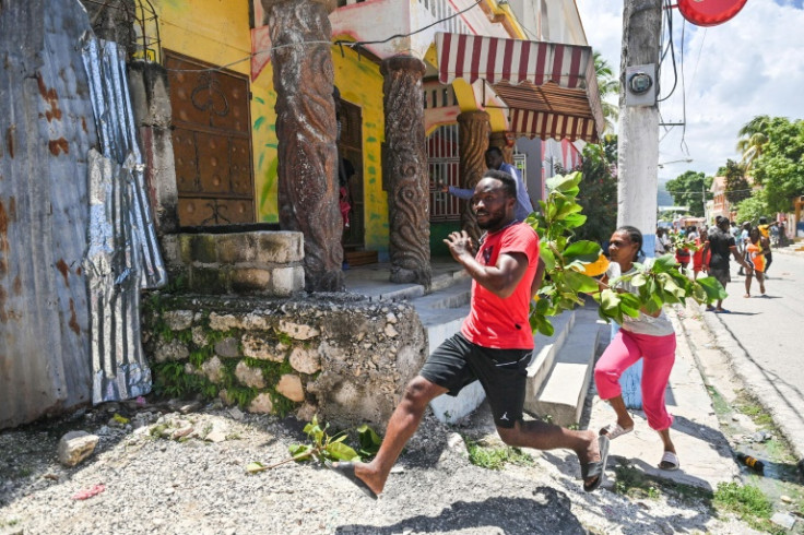 A man flees tear gas as people demonstrate over the rise in the cost of living in Petit-Goave, Haiti on September 14, 2023