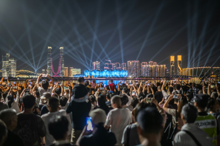 People watch a light show of the Hangzhou Olympic Sports Centre Stadium