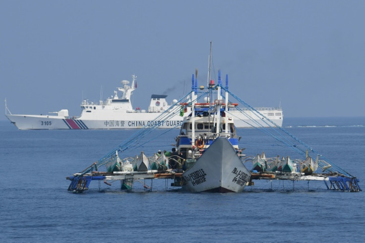A Chinese coast guard ship (background) shadows a Philippine fishing boat. China claims sovereignty over almost the entire South China Sea