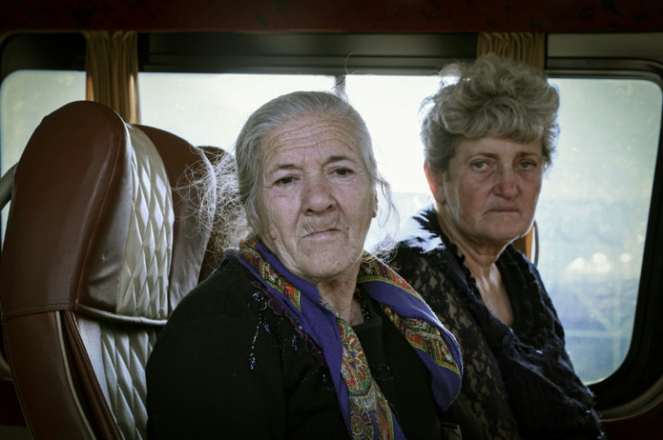 Refugees sit in a bus after registering at a centre of the Armenian foreign affairs ministry near the border town of Kornidzor