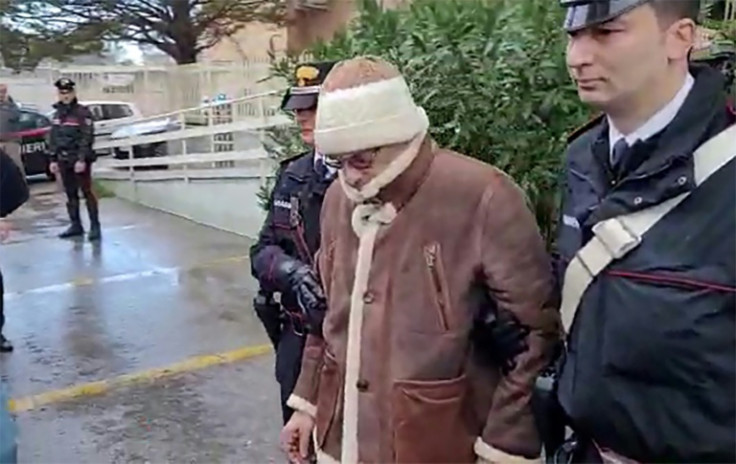 This handout video grab taken and released by the Italian Carabinieri Press Office on January 16, 2023 shows the transfer of mafia boss Matteo Messina Denaro (C) to an undisclosed location following his arrest