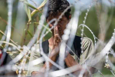 A migrant from Venezuela prays after crossing the Rio Grande to Eagle Pass, Texas