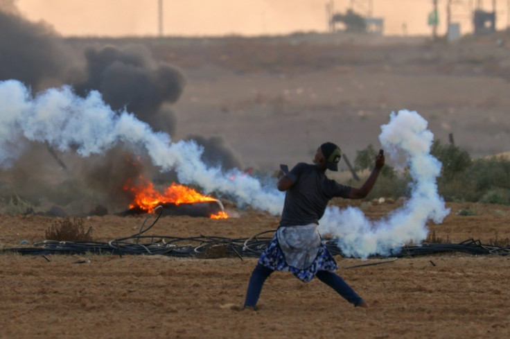 A Palestinian demonstrator hurls back a tear gas canister during clashes with Israeli soldiers east of Rafah in the southern Gaza Strip on September 23, 2023