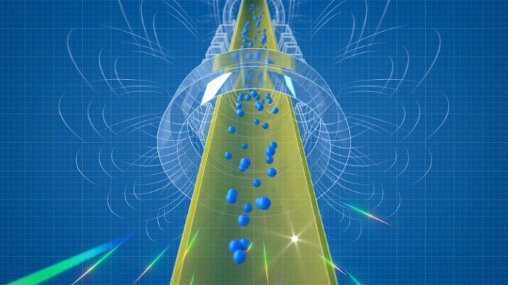 An illustration of anthydrogen atoms flowing mostly downwards in the cylinder, showing the effect of gravity's pull