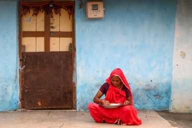 A woman sifts dehusked rice at her house in Tankari Bandar village in India's western state of Gujarat, which researchers say is the site of the first recorded game in the country