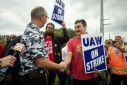 United Auto Workers President Shawn Fain greets UAW members as they strike the General Motors Lansing Delta Assembly Plant in September 2023