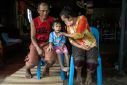 Paweenuch "Ammy" Supolwong, 4, who survived a nursery massacre in 2022, with her grandparents Yupin Srithong (R) and Somsak Srithong