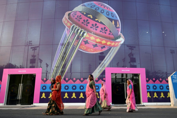 'Cricket crazy': Women along with a child walk inside the complex of the Narendra Modi Stadium