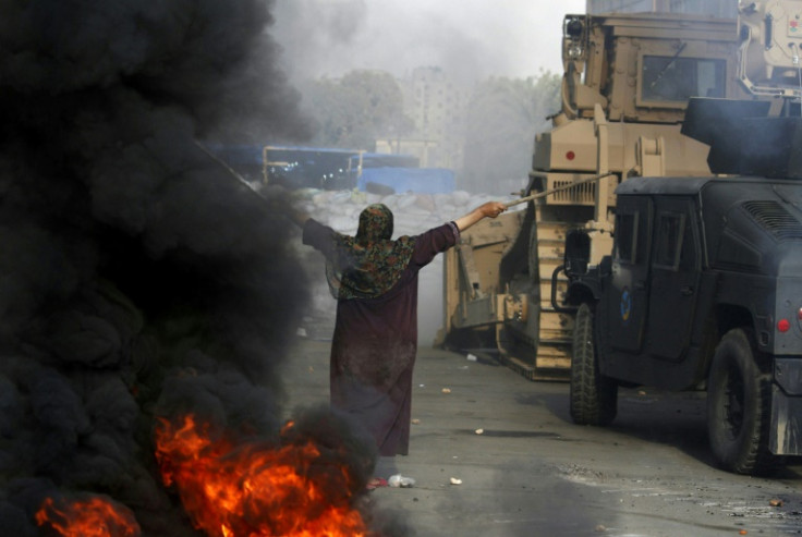 An Egyptian woman tries to stop a military bulldozer during clashes as security forces moved to disperse supporters of Egypt's deposed president Mohamed Morsi in eastern Cairo on August 14, 2013