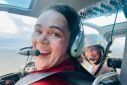 This handout photo dated July 13, 2022, shows firefighter Kara Galbraith (L), in a helicopter Carmacks, Yukon, Canada, flying to a fire. Galbraith was deployed with an Initial Attack Crew to help with the fires in the Yukon