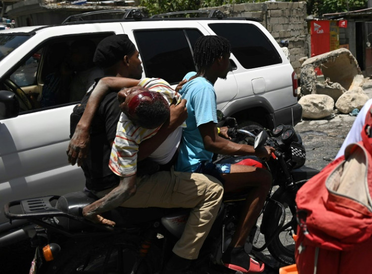 An injured man is transported on a motorcycle to a hospital after he was reportedly shot during gang violence in Port-au-Prince, Haiti earlier this year