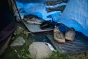 Shoes belonging to a woman are left just outside her tent in a makeshift homeless encampment in a park in Granby, Canada