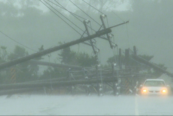 A car passes by downed power lines after powerful winds from Typhoon Koinu hit Taiwan's southern Pingtung County