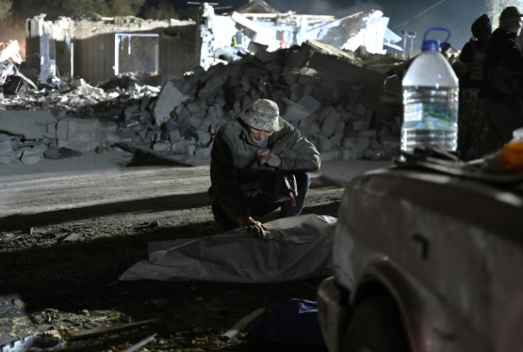 Sergiy crouched over the body bag, one hand rested on the top of the white plastic