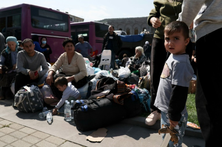 Armenian refugees wait in a square of Goris before being evacuated to other cities