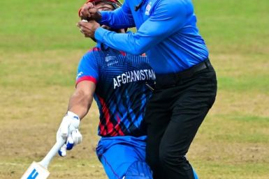 Afghanistan’s Gulbadin Naib (L) collides with the umpire