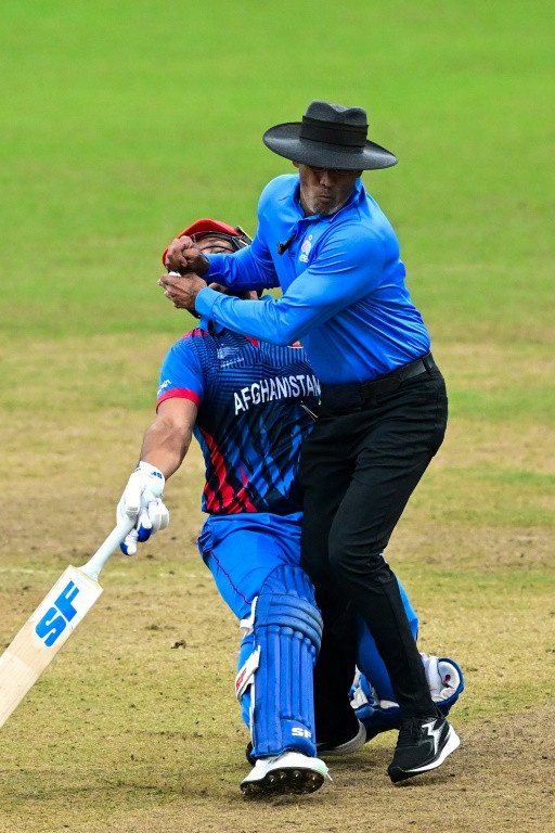Afghanistan’s Gulbadin Naib (L) collides with the umpire