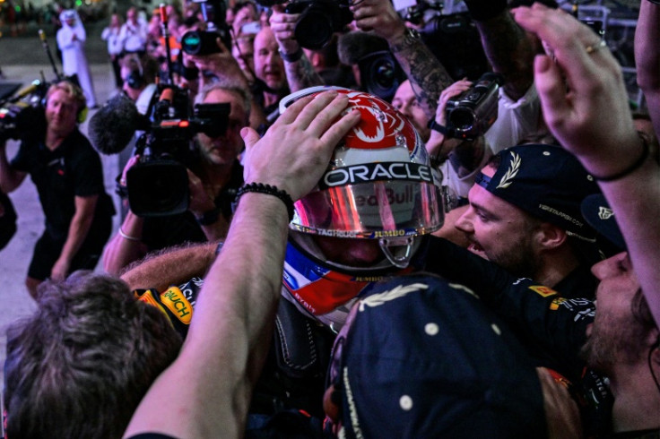 Team man: Max Verstappen celebrates with Red Bull team in the paddock in Doha