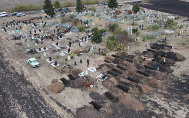 An aerial photograph taken with a drone shows workers digging graves for the victims of an air strike in the Groza village of Ukraine's Kharkiv region