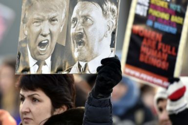 A participant of a Women's March in Helsinki holds up a poster depicting US President Donald Trump and German dictator Adolf Hitler on January 21, 2017, one day after the US president's inauguration