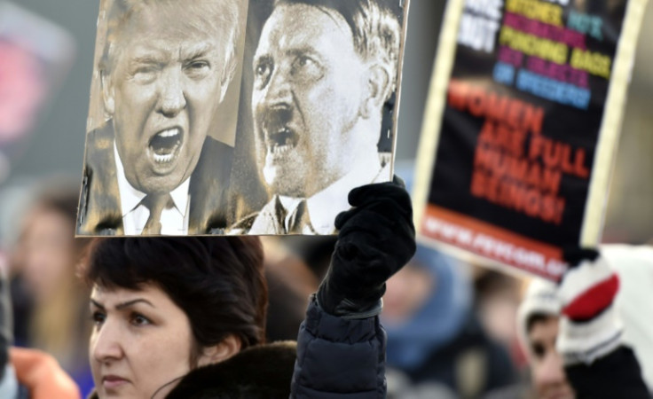 A participant of a Women's March in Helsinki holds up a poster depicting US President Donald Trump and German dictator Adolf Hitler on January 21, 2017, one day after the US president's inauguration