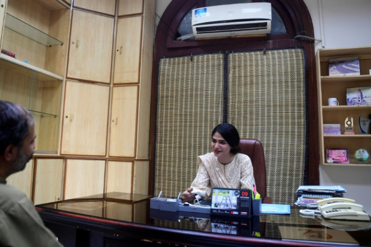 Transgender activist and Karachi municipal council member Shahzadi Rai (R) speaks with her colleague at her office
