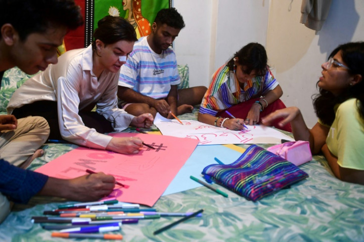 Mehrub Moiz Awan (2L) and her team members prepare placards for a gender-rights protest in Karachi