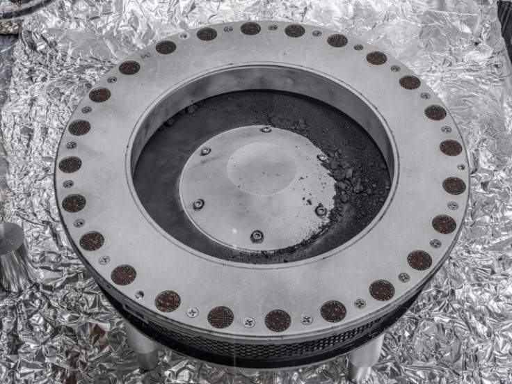 In this image by NASA in Houston, Texas shows the outside of the OSIRIS-REx sample collector with sample material from asteroid Bennu