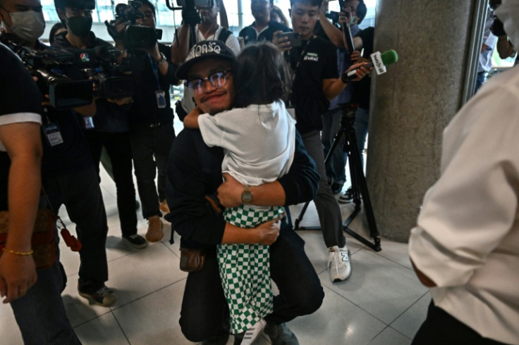 A Thai man hugs a family member after returning on a flight from Israel