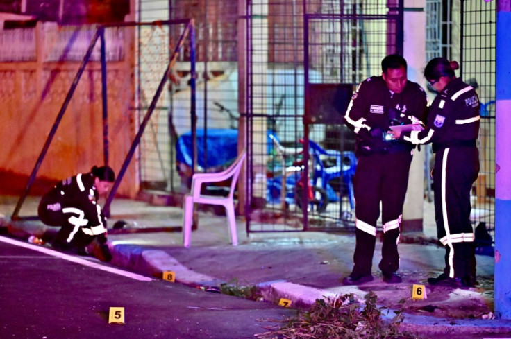 Police officers perform forensic examinations at the scene of a murder in Guayaquil