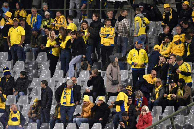 Sweden supporters wait inside the ground after their team's game against Belgium was stopped in the wake of an attack in Brussels