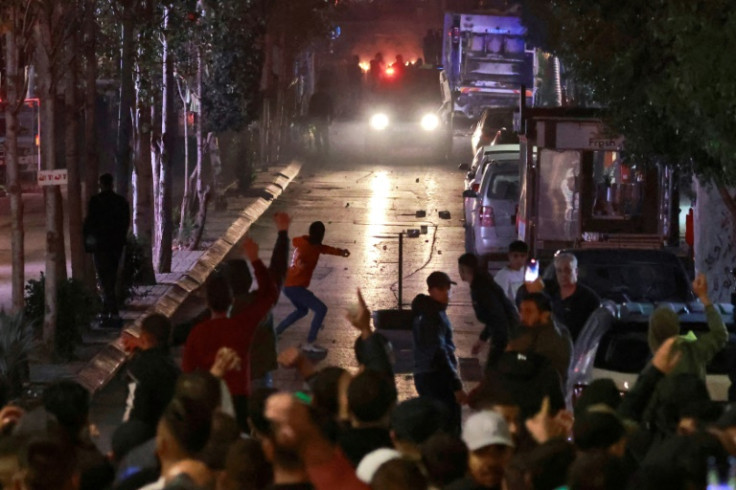 People clash with Palestinian security forces during a rally in solidarity with the Palestinians of the Gaza Strip in the West Bank city of Ramallah, on October 17, 2023.  Israeli air strikes on a Gaza hospital compound on October 17 killed at least 200 p