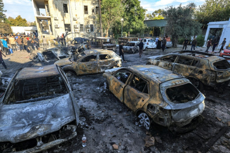 Palestinians gather at the site of the Ahli Arab hospital in central Gaza on October 18, 2023 in the aftermath of an overnight blast