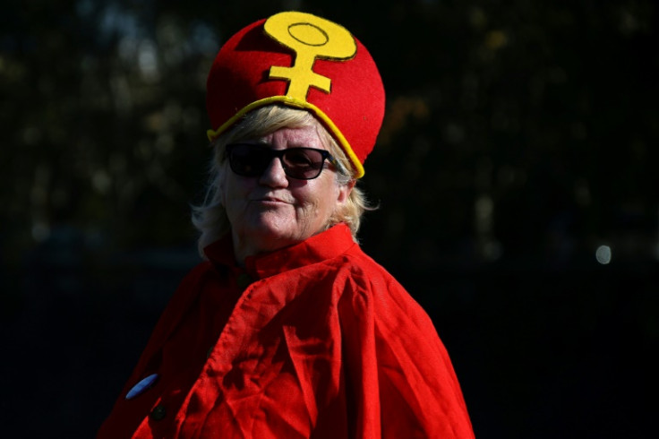 A WOC supporter dressed as a Pope with red vestments takes part in a demonstration
