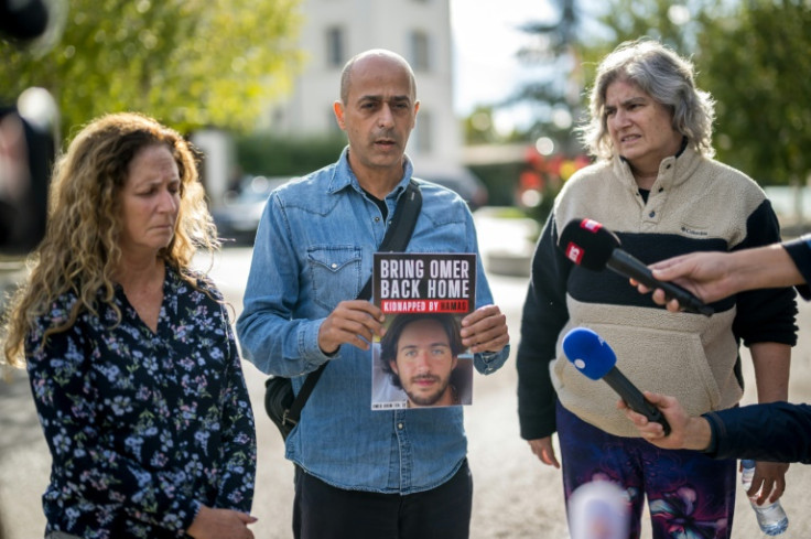 Relatives of Israelis missing or held hostages by the Hamas (From L) Doris Liber representing her son Guy Iluz, Assaf Shem Tov, showing a picture of his 21-year-old nephew Omer Shem Tov and Michal Dorset representing her niece Romi Gonen