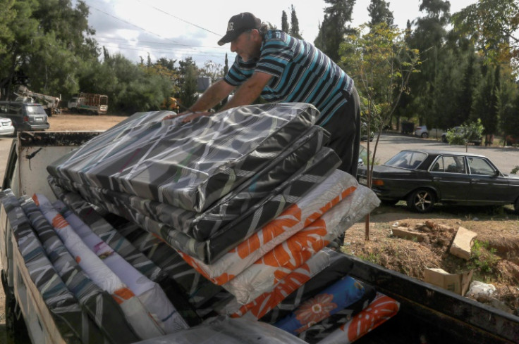 Workers deliver relief supplies to displaced families staying in several schools in Tyre