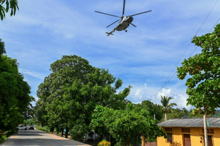 A Mexican police helicopter flies over the scene of the attack