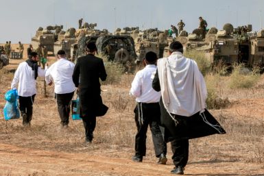 Ultra-Orthodox Jews visit Israeli army soldiers to show their support as they deploy at a position near the border with Gaza in southern Israel on October 11, 2023.