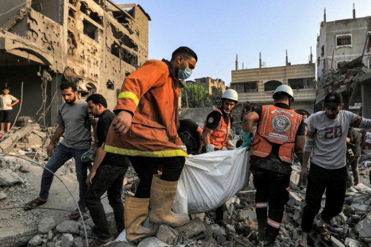 Palestinian civil defence members carry the body of a person killed during Israeli bombardment in Khan Yunis in the southern Gaza Strip on October 25, 2023