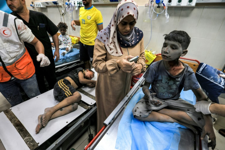 A woman waits with two children injured in Israeli bombardment at the trauma ward at Nasser hospital in Khan Yunis in the southern Gaza Strip on October 24, 2023