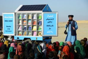 In this photograph taken in 2022, Matiullah Wesa, head of PenPath and advocate for girls' education in Afghanistan, speaks to children during a class next to his mobile library in the Spin Boldak district of Kandahar Province