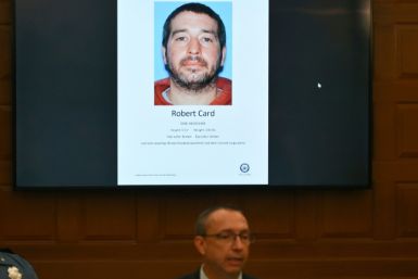 Maine Department of Public Safety Commissioner Mike Sauschuck speaks during a press conference at Lewiston City Hall in Lewiston,  Maine, under a picture of suspect Robert Card on October 27, 2023