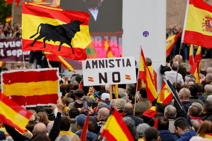 Protestors wave Spanish national flags and a sign reading "No Amnesty" at a rally in Madrid called by far-right party Vox