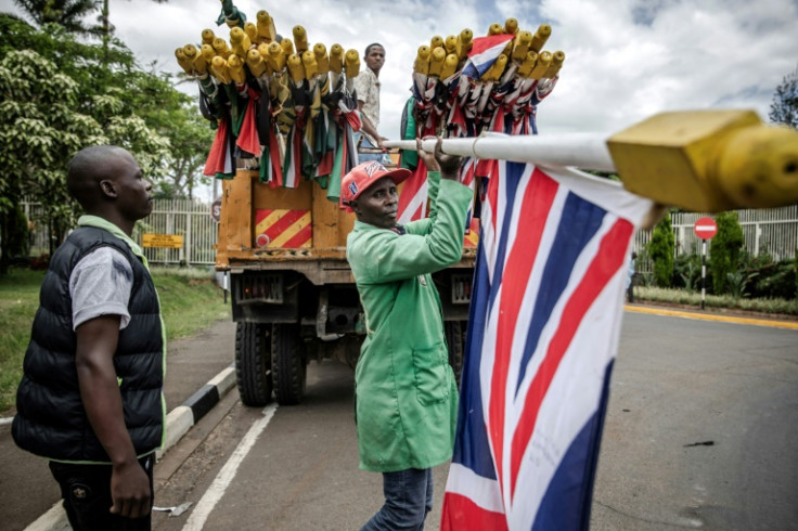 Workers in Nairobi set up flags ahead of the visit by King Charles and Queen Camilla