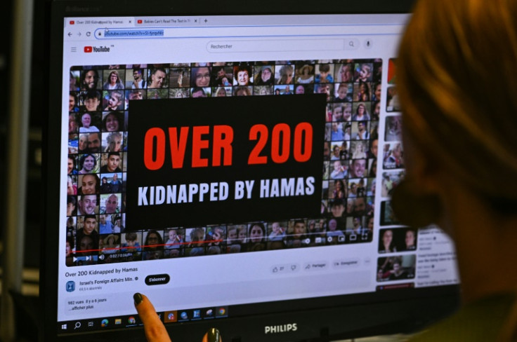 This photograph taken on October 26, 2023, shows a woman looking at a computer screen in Paris, displaying an advertisement on the YouTube platform for a campaign financed by The Israeli Ministry of Foreign Affairs. Thousands of civilians, both Palestini
