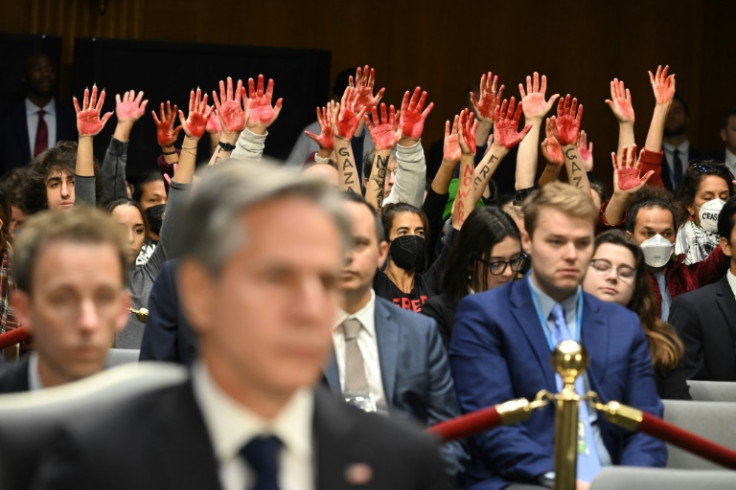 Protesters raise their painted hands as US Secretary of State Antony Blinken testifies during a Senate Appropriations Committee hearing to examine the national security supplemental request, in Washingotn October 31, 2023