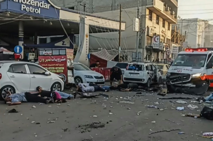 This image grab taken from an AFPTV video footage shows victims lying near an ambulance damaged in a reported Israeli strike in front of Al-Shifa hospital in Gaza City