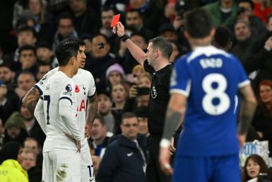 Michael Oliver shows a red card to Tottenham's Cristian Romero