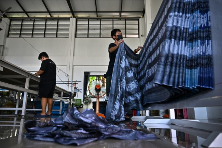 Workers in Chiang Mai prepare to cut elephant print fabric into clothing patterns