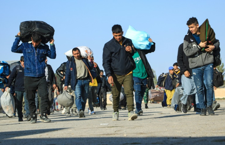 Afghans deported from Iran carry their belongings to a registration centre near the Islam Qala border crossing in Herat province